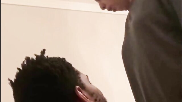 Black man kneels submissively as dominant woman towers over him in femdom scene