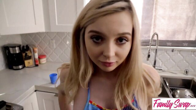 Blonde Family Swap teen in skimpy bikini smiles teasingly in kitchen