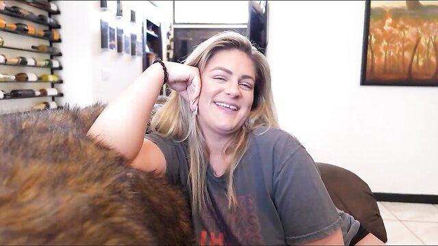 Clover Baltimore blonde MILF smiles sexy on couch in tight tee