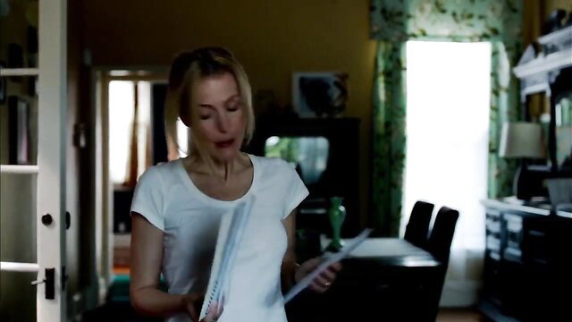 Gillian Anderson in tight white tank top, blonde hair, sexy indoor scene