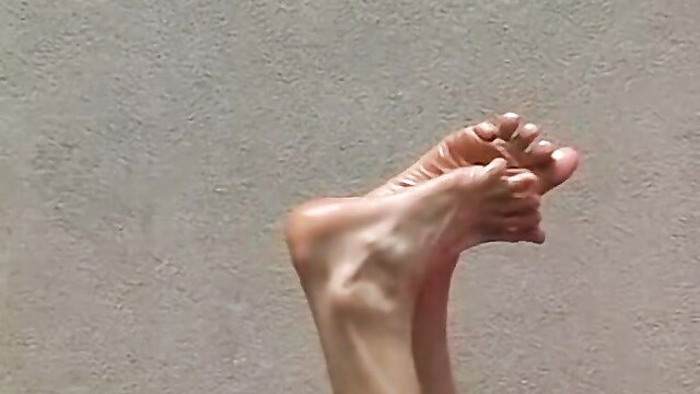 Closeup of flexible bare female soles and toes flexed upward