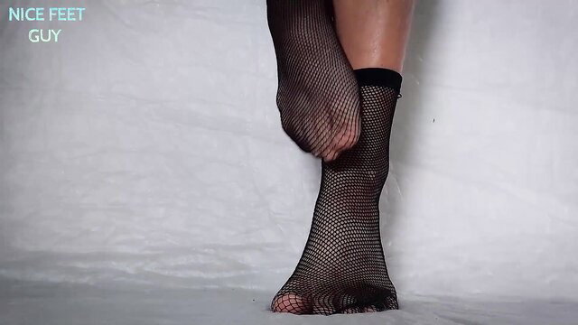 Woman's sexy fishnet stockings soles and feet taunting man