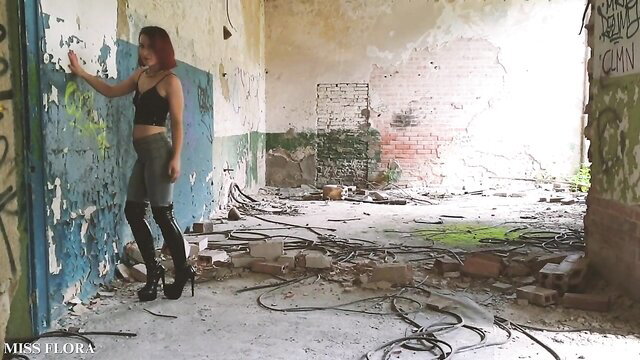 Redhead in tight jeans and high boots teases flawless ass in ruined room