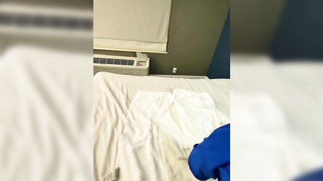 Amateur woman in white sheets and blue top on bed, nearly running away tease