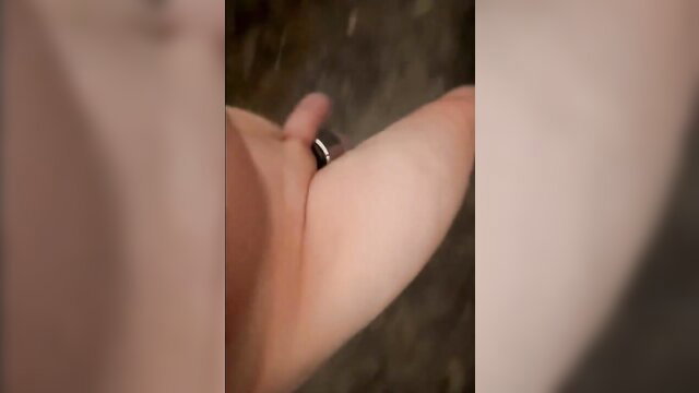 Closeup of woman's bare arm and black ring in forest, naked barefoot walk tease