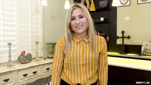 Blonde Lindsey Cruz smiling in yellow striped blouse kitchen scene