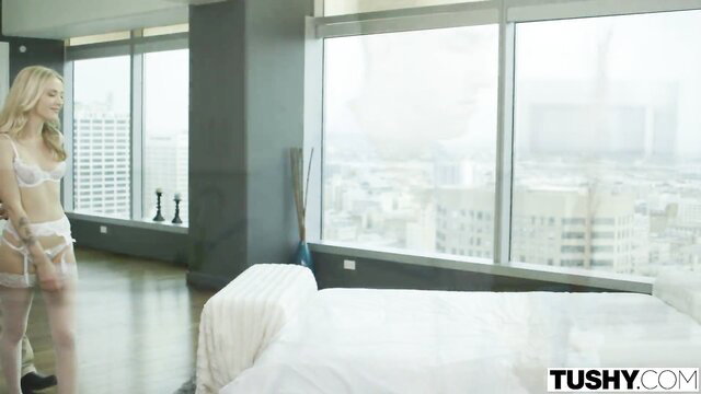 Karla Kush in white lingerie by window in luxury penthouse