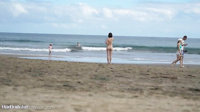 Eve Sweet naked on beach, nude brunette standing by ocean waves