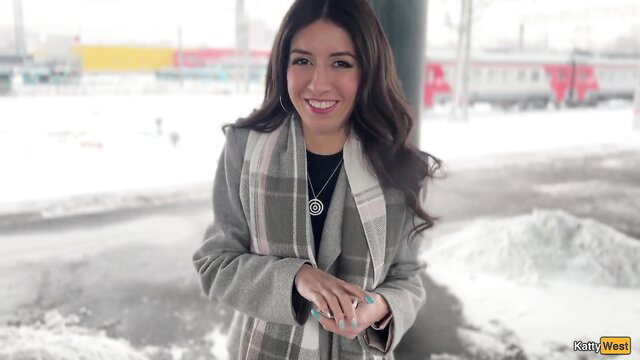 Katty West smiling in coat at snowy train station - Public Agent