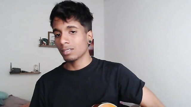 Young Indian guy with guitar in casual black tee, amateur cam thumbnail