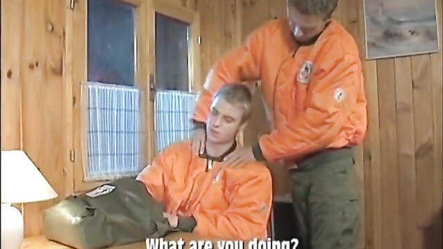 Two hot blond guys in orange flight suits, one groping the other's neck intimately