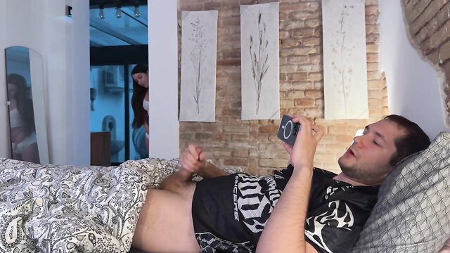 Hot guy in bed holding phone, nude bulge visible, amateur nude tease