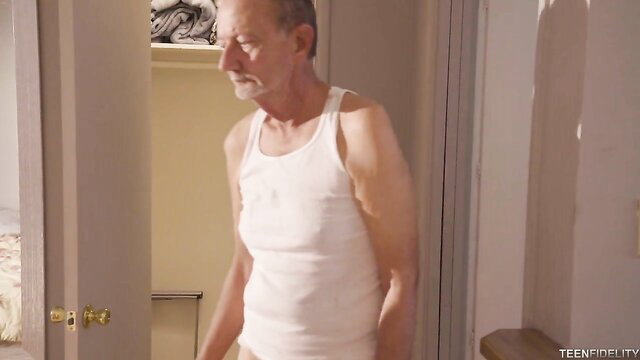 Older man in tighty whities and tank top in bedroom closet
