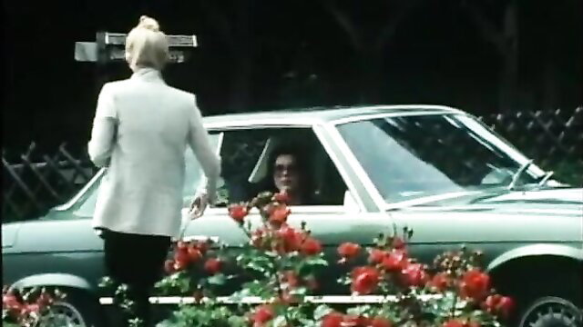 Blonde woman in white suit leans into green Mercedes for sex in classic Ribu Aristokrat 25