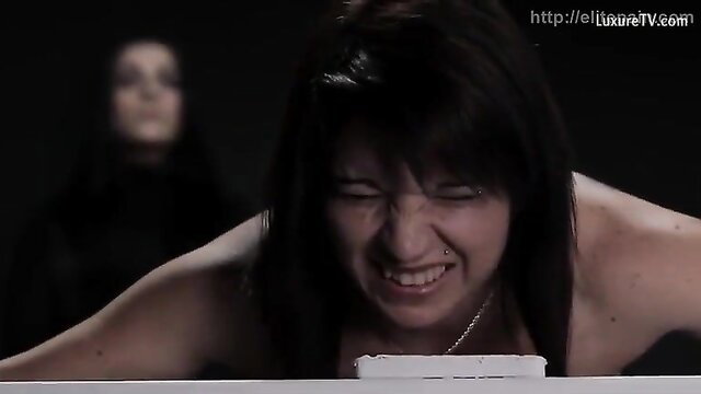 Brunette grimacing in ecstasy, arms spread nude on table