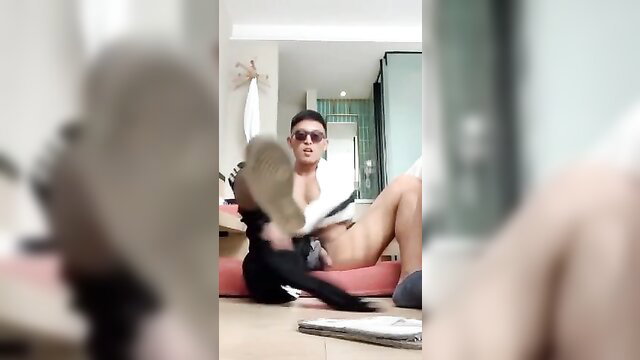 Muscular Asian man teased with shoe in erotic domination play