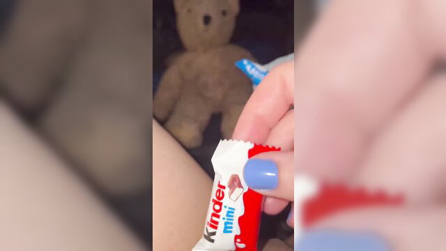 Arab teen handholds Kinder chocolate & teddy bear closeup