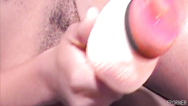 Ebony teen handholding pink sex toy brush on smooth thigh