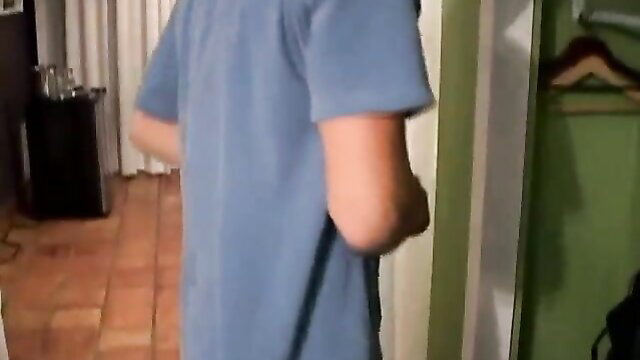 Blonde guy in blue t-shirt stands by closet door in bedroom