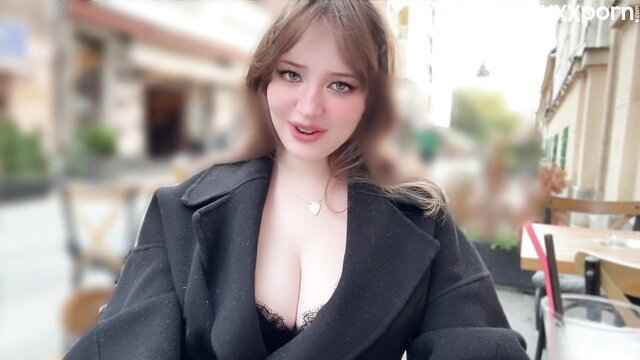 Brunette beauty in deep cleavage coat smiles seductively at cafe