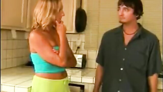 Blonde mature in tube top and hotpants chats with guy in kitchen