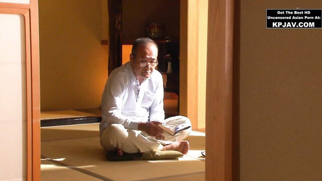 Japanese mature man in white shirt pants sitting on tatami reading book