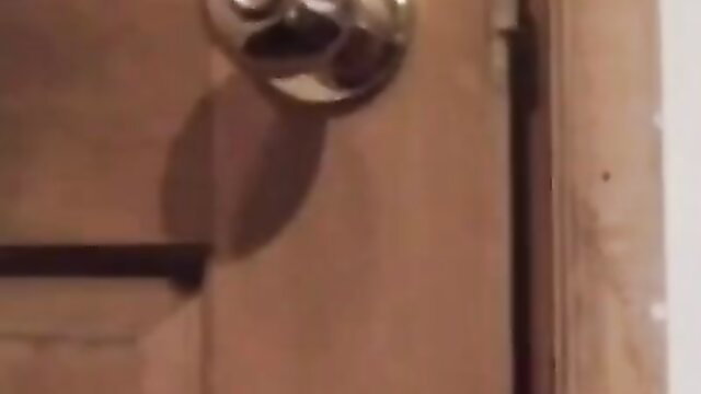 Closeup of mature woman's hand on shiny brass doorknob in taboo tease