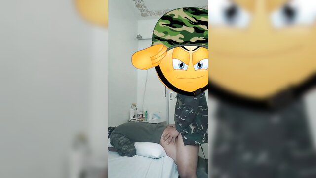 Filipino soldier in camo shorts stands over man on bed, amateur tease