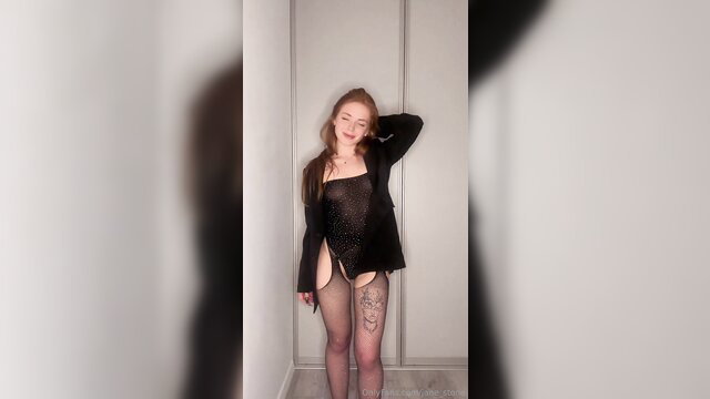 Redhead Jane Stone in sheer lingerie poses sexy, tattooed legs