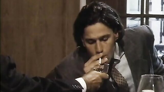 Handsome Asian man in suit smoking cigarette closeup