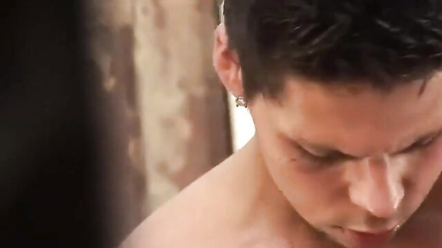 Closeup of handsome young man's intense face in steamy gay adult scene