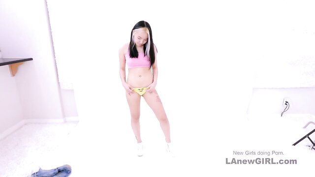 Asian girl in pink top and yellow underwear posing