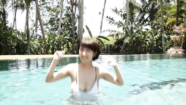 Busty Asian teen in white bikini posing by pool, wet softcore tease