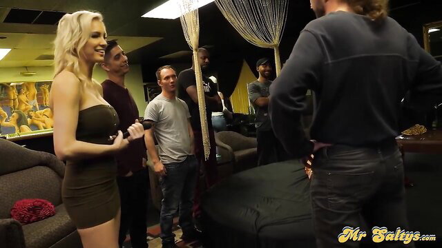 Busty blonde mom in green mini dress surrounded by men in bukkake setup
