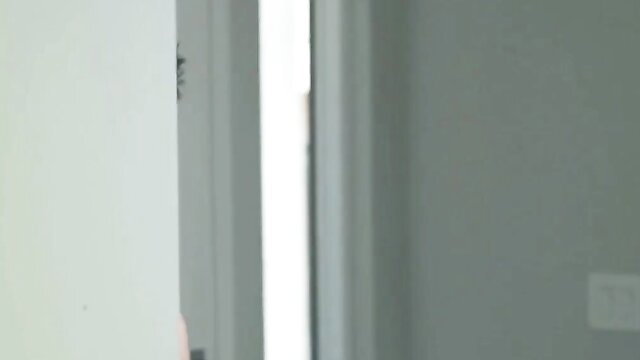 Slim Asian woman in lingerie poses by door in sexy indoor scene