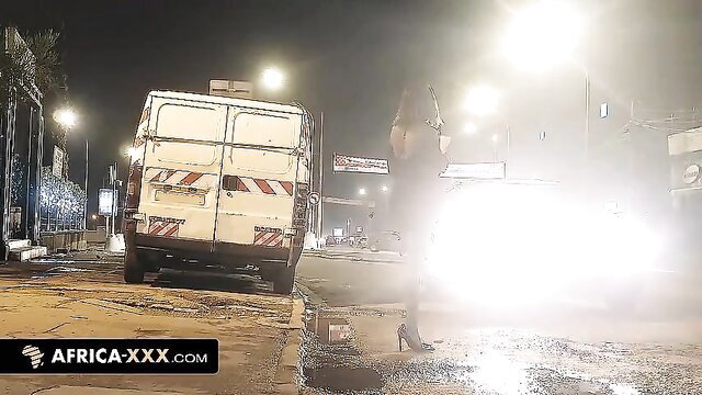 Sexy black woman in dress approaches white taxi van at night