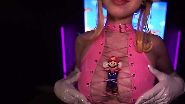 Blonde Princess Peach cosplay babe with Mario toy in pink lace-up lingerie