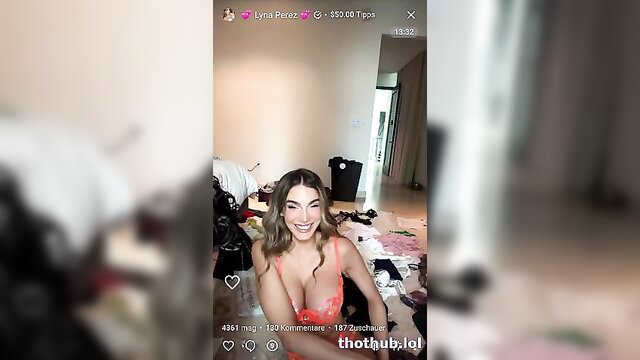 Lyna Perez smiling in tight red top with deep cleavage selfie