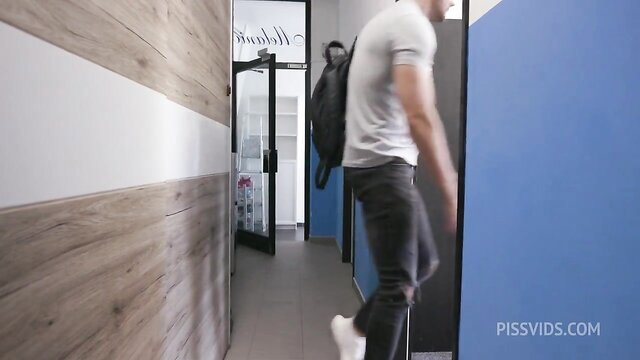 Hot guy in tight white tee and jeans walks gym hallway