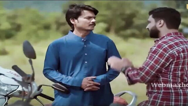 Two handsome Indian men in traditional attire chatting outdoors near motorcycle