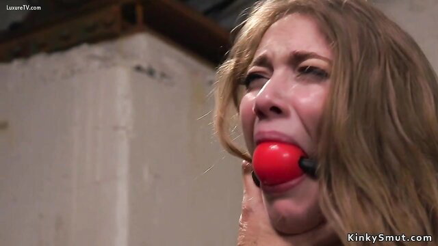 Blonde gagged woman in BDSM play, tears of ecstasy, closeup