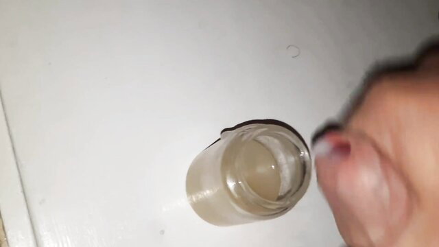 Amateur hand holds jar of thick cum close-up, jism chalice fetish