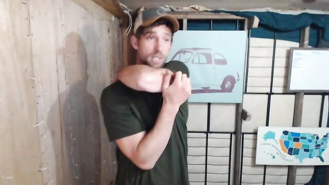 Masculine man in green shirt gripping arm, car art background