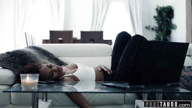 Scarlit Scandal lounging sexy in sports bra and leggings on couch