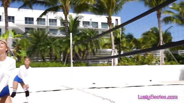 Sultry blonde bombshell in bikini spikes volleyball on sunny beach