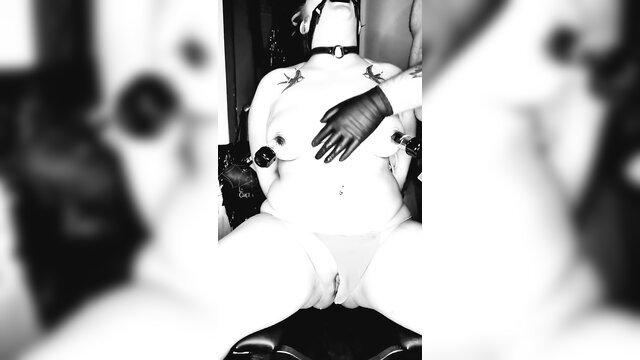 Goth slut bound to chair, gloved hands on tits, gagged in bondage