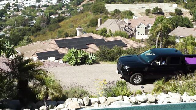 James Angel and Lacey Jayne by black truck at sunny hilltop home