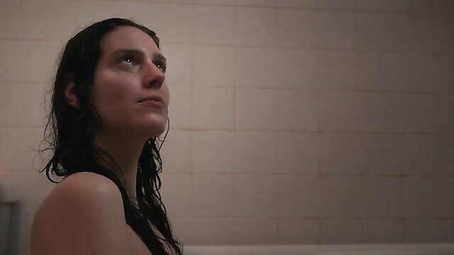 Eva Victor in a bathroom, topless and looking up