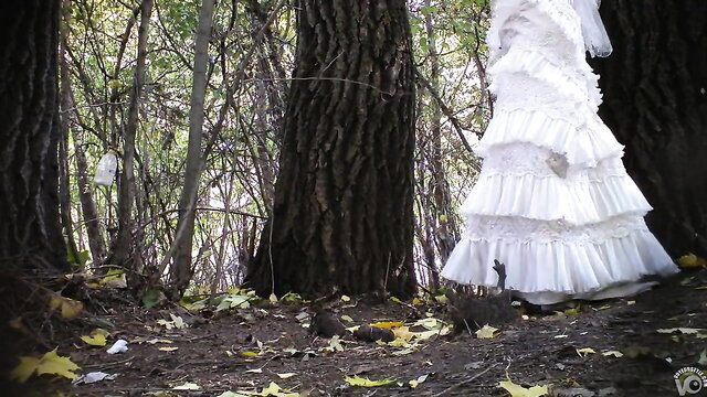 Russian bride in white wedding dress stands in woods with bridesmaids