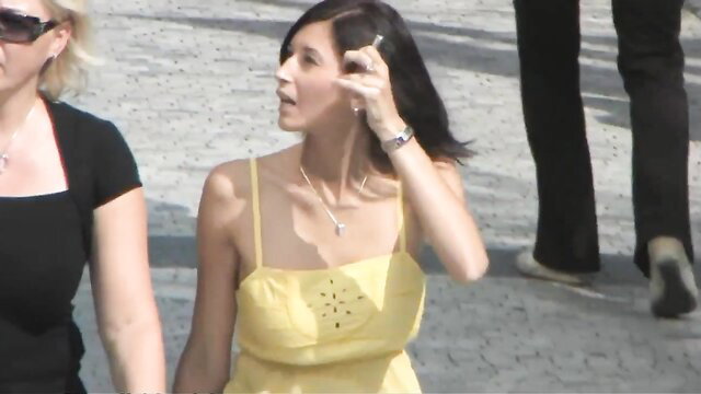 Raven-haired looker in yellow sundress on phone outdoors